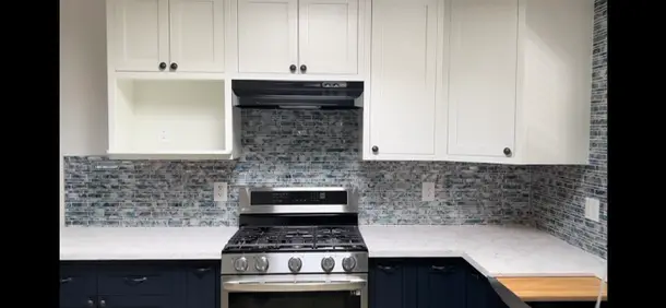 Valle Vista kitchen remodel photo from PL Builders showing finished white cabinet, tile backsplash, countertop, sink, and appliance layout