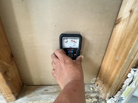 Moisture meter reading at affected wall during San Jacinto restoration documentation